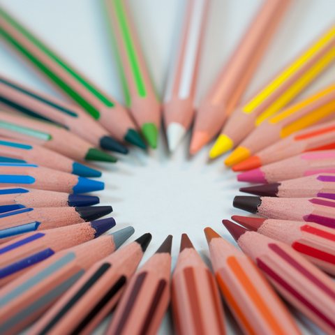 Many colored pencils arranged in a circle