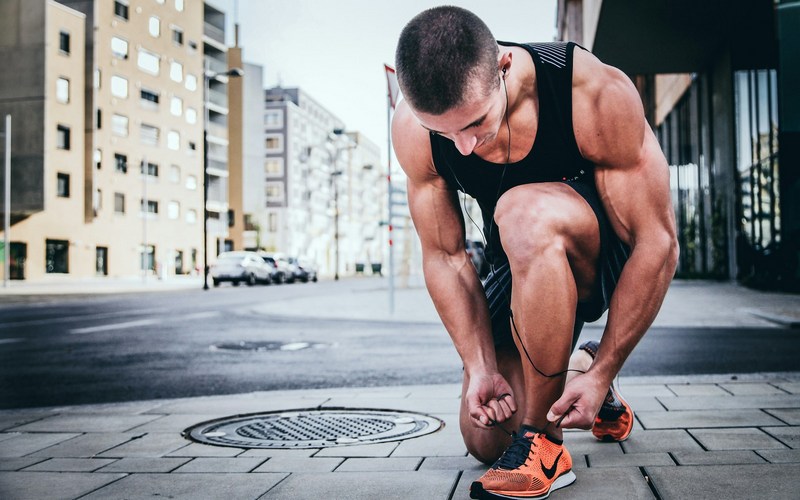 A runner tying his shoelaces before starting 